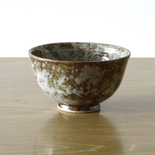 Pottery bowl in reddish brown color and dappled glaze